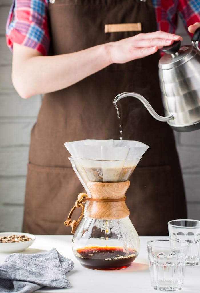 why-choose-us Barista pours hot water into Chemex for fresh drip coffee. Perfect for caffeine lovers.
